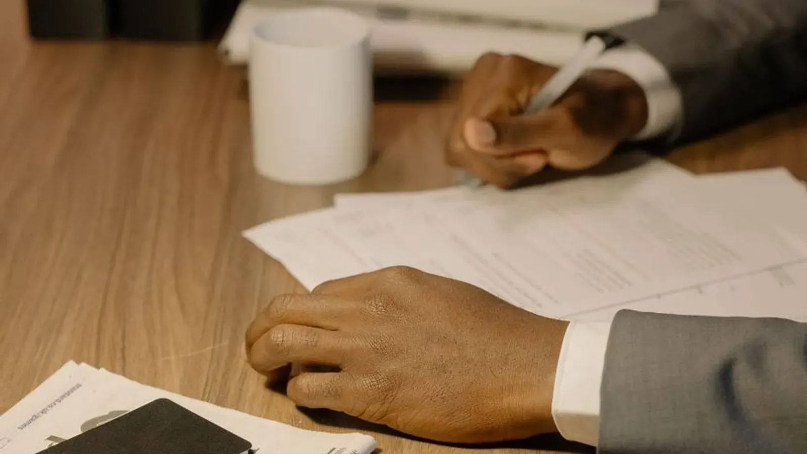 Investigator writing the final report with case documents and a magnifying glass