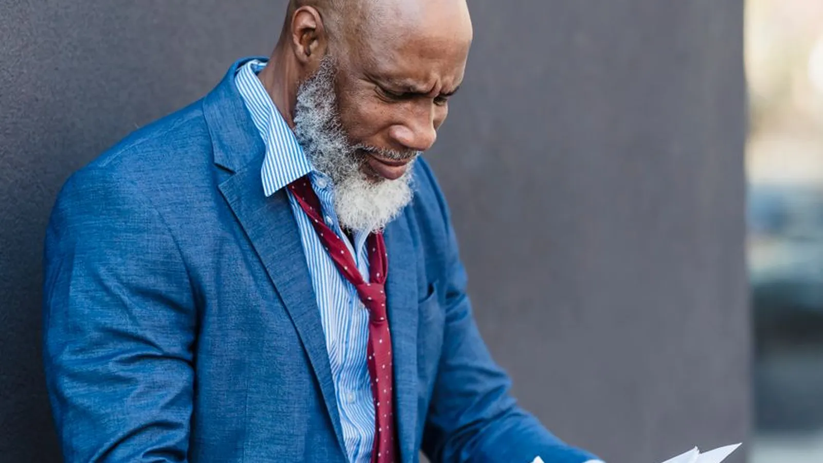 A businessman in an office reviewing a document with a concerned expression, representing the moment a fraud pattern first becomes visible