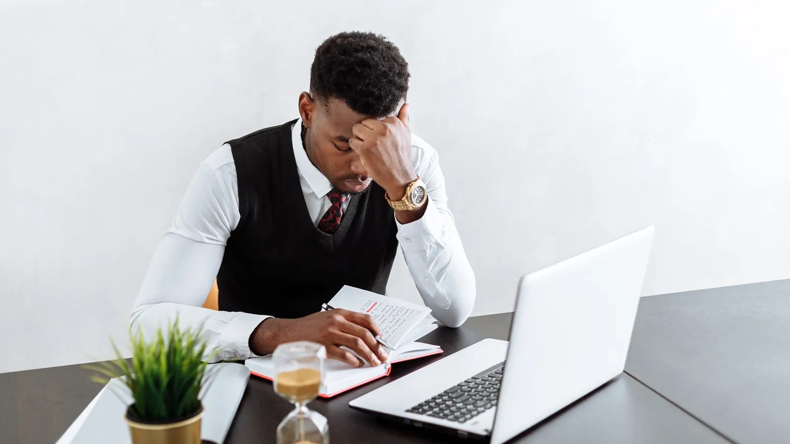 A man leaning on his hand at a laptop, weighing a decision, representing the honest assessment of whether a real deadline is attached to the situation