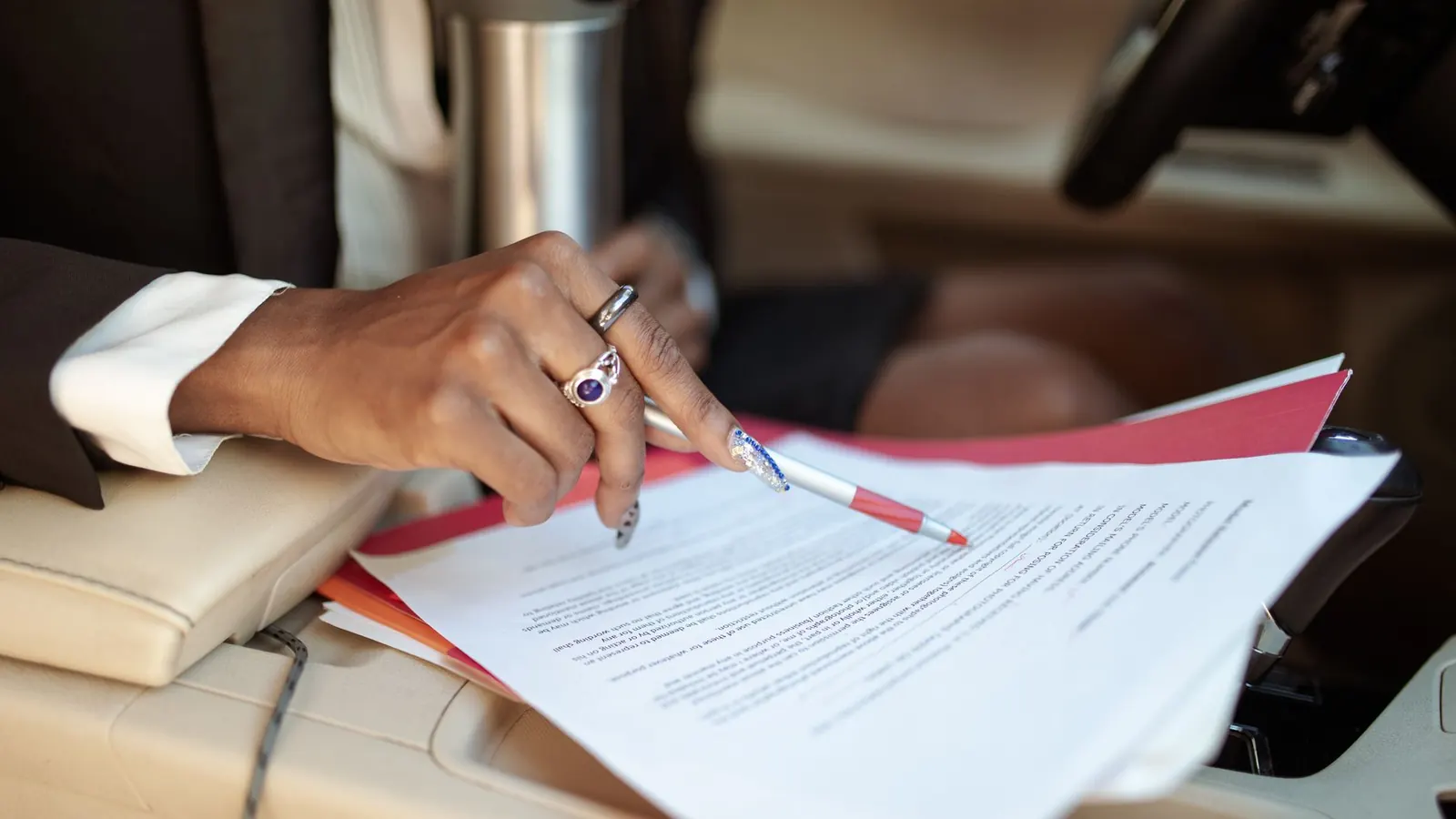 A hand marking up a contract with a red pen, representing the verification work behind corporate due diligence