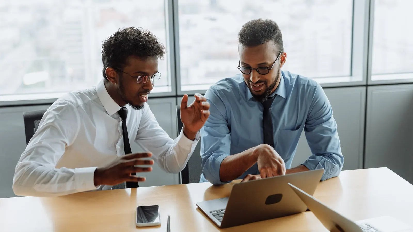 Two colleagues closely reviewing information on a laptop screen, representing the investigation work behind verifying a competitor or former-employee threat