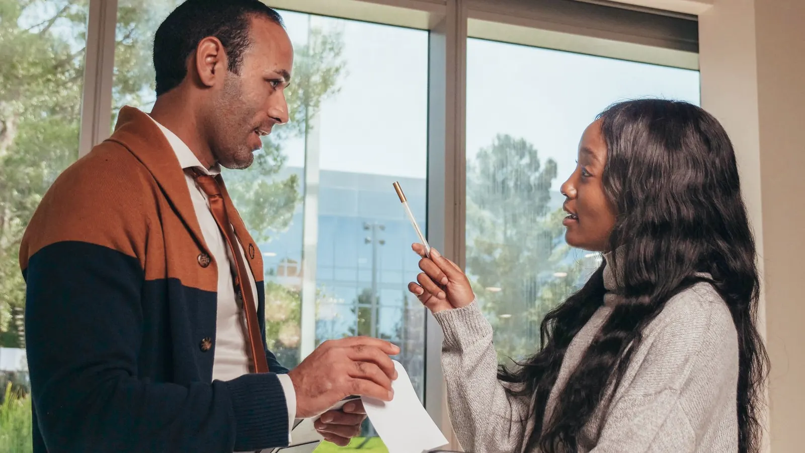 Two colleagues in an animated discussion in an office, representing a workplace dispute that needs a fair, documented investigation