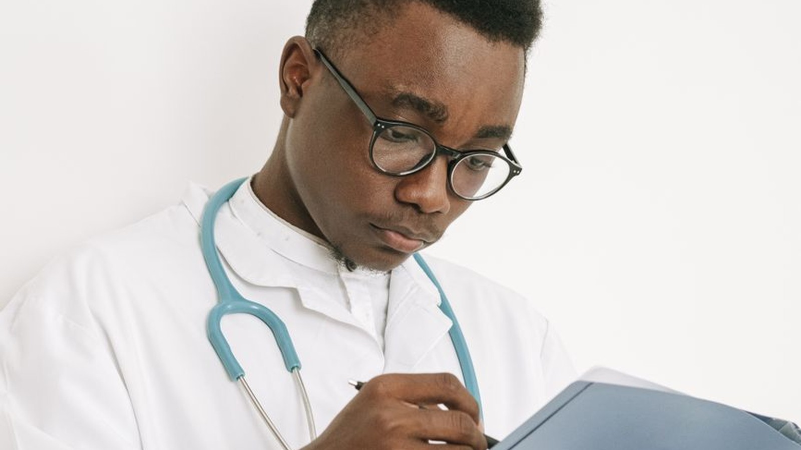 Doctor reviewing medical records on a clipboard, representing the documentation verified during a life or health insurance claim investigation