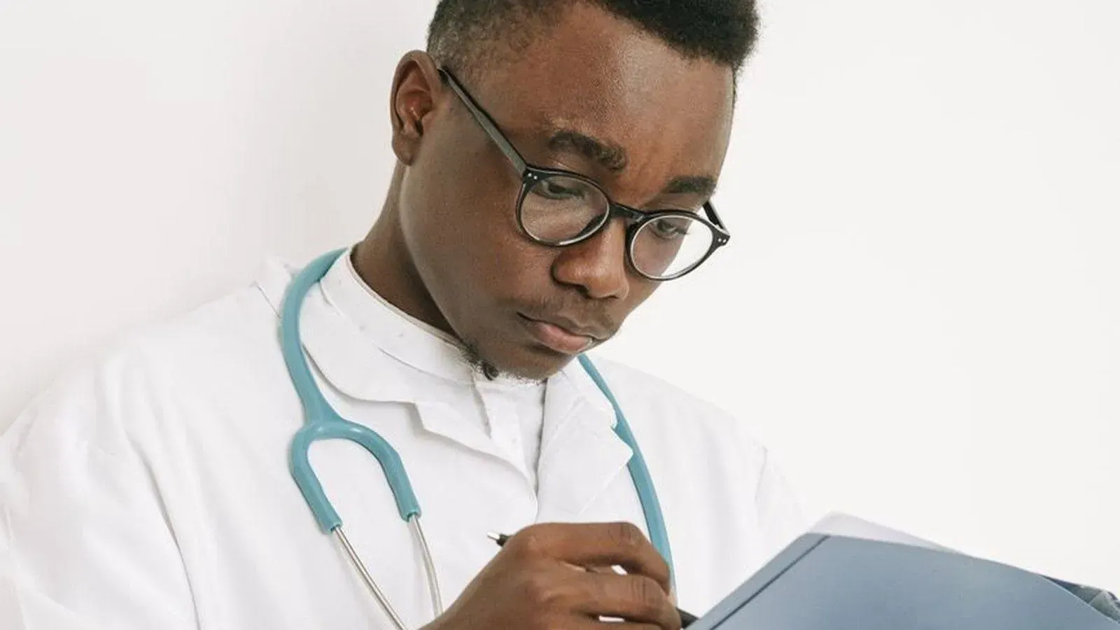 Doctor reviewing medical records on a clipboard, representing the documentation verified during a life or health insurance claim investigation