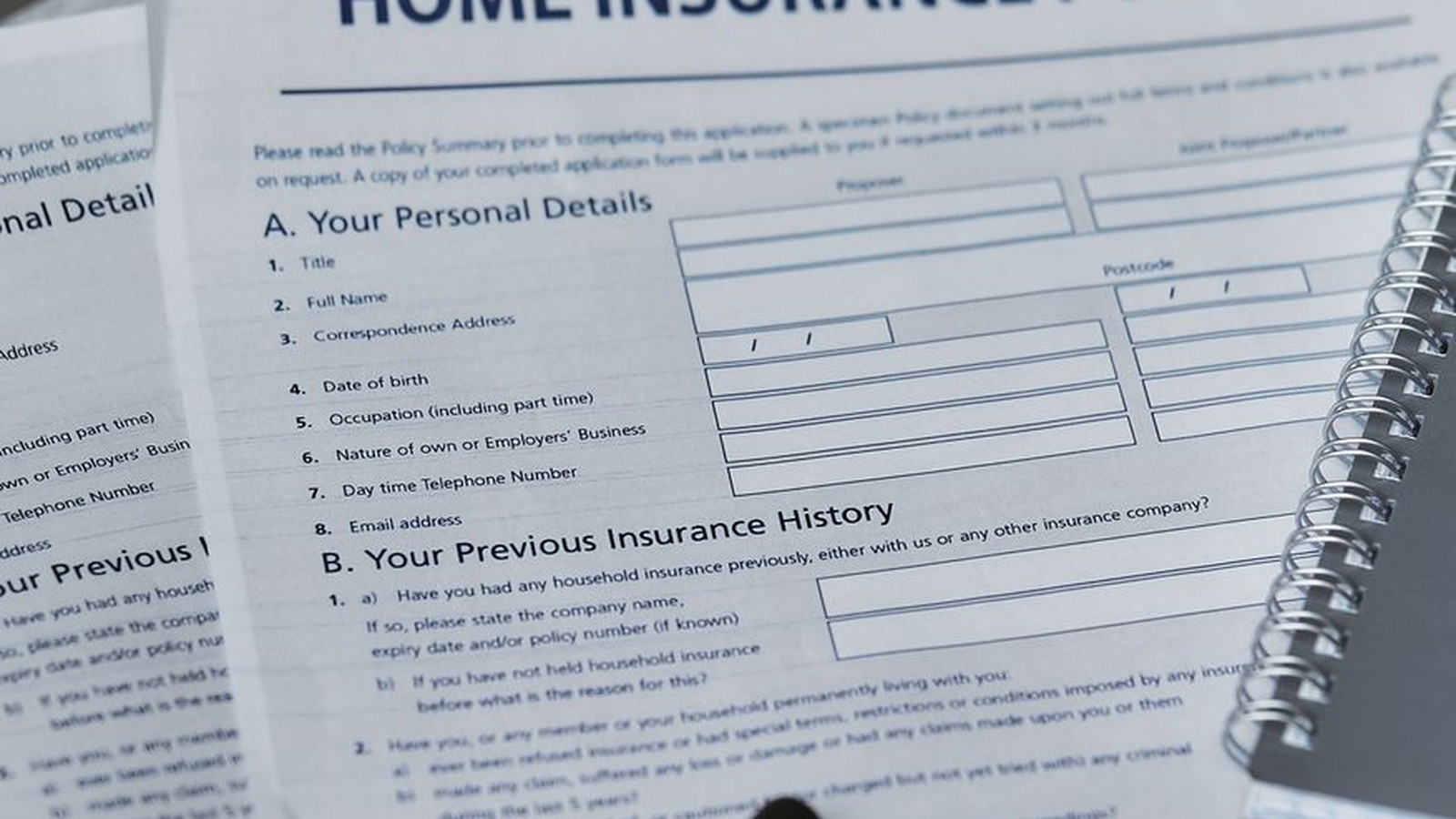Home insurance policy document with a pen, representing the paperwork behind an insurance claim in Tanzania