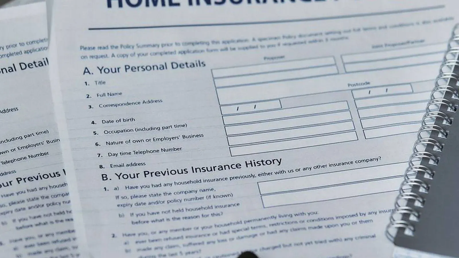 Home insurance policy document with a pen, representing the paperwork behind an insurance claim in Tanzania