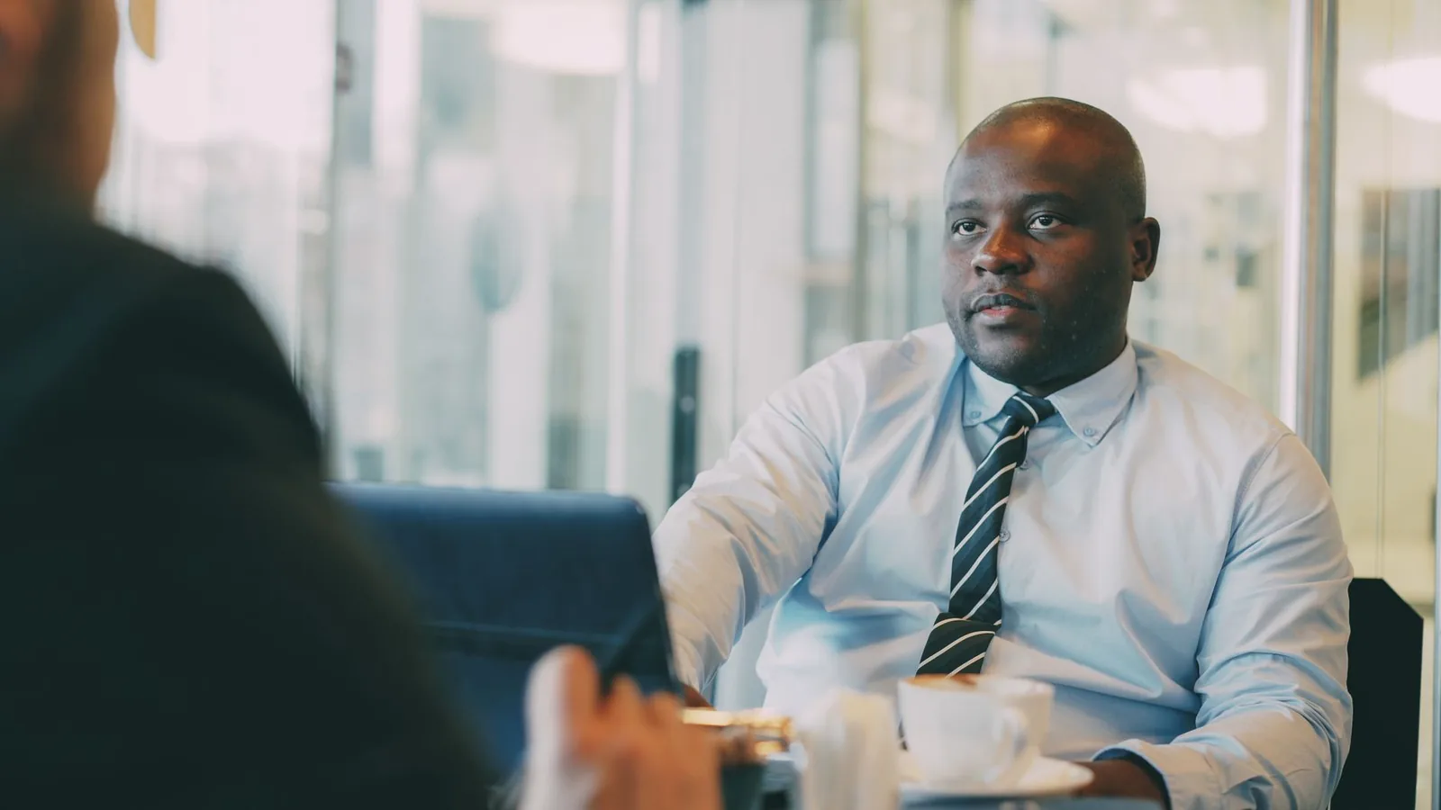 An African businessman being interviewed across a table, representing vetting local leadership hired from abroad