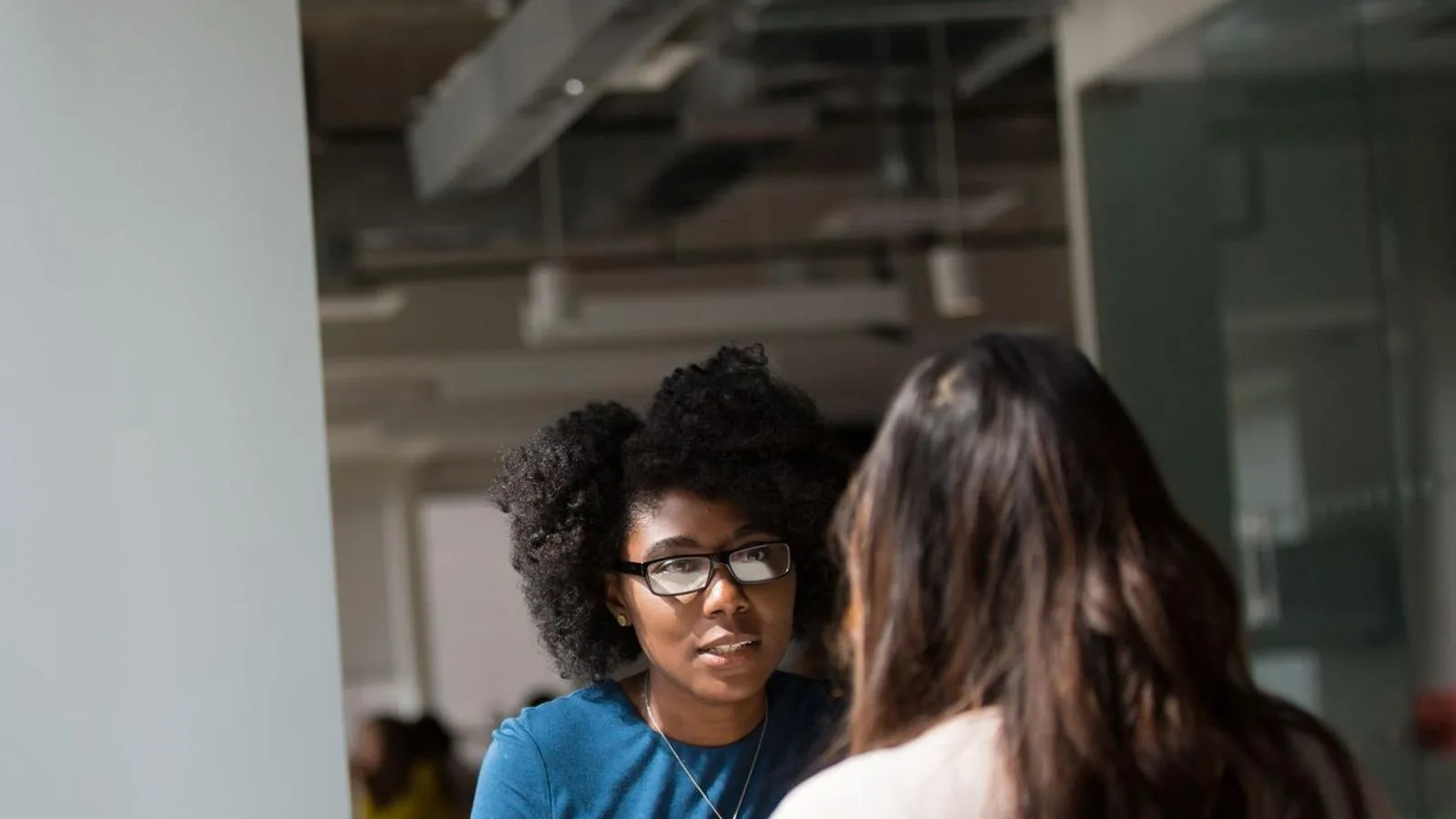 Two women having a serious conversation in an office, representing an independent workplace investigation for a local team