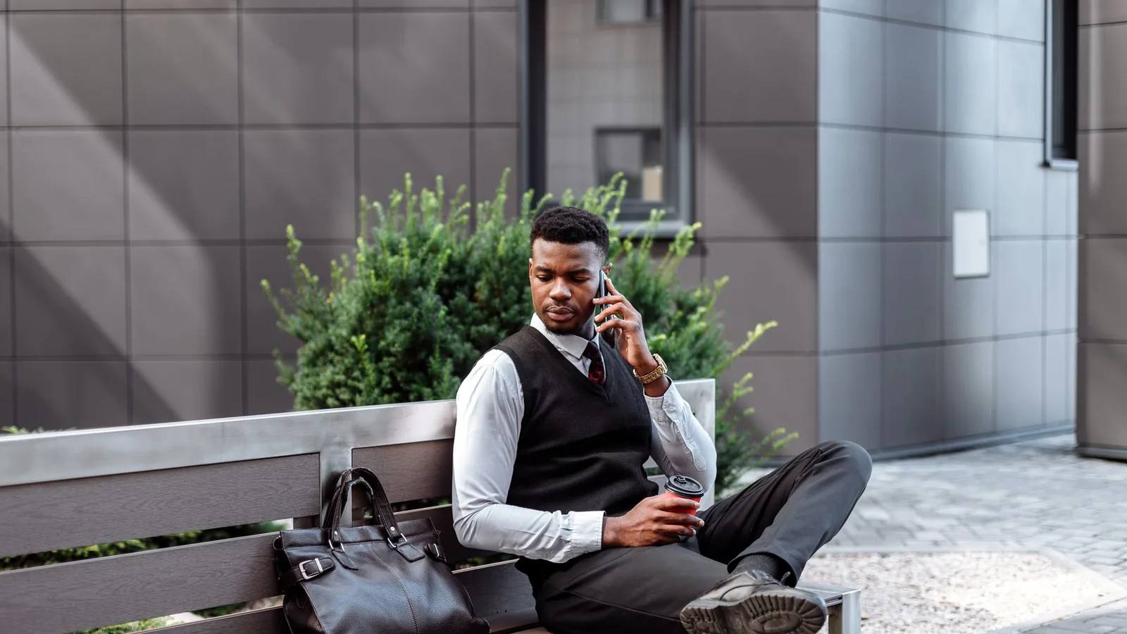 A man sitting outside quietly on the phone, representing a private, undisclosed conflict of interest being checked before a deal
