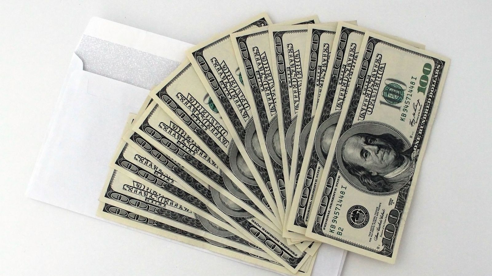 Cash fanned out from an envelope, representing a kickback or bribery investigation into vendor collusion