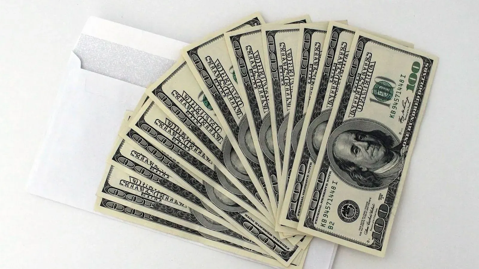 Cash fanned out from an envelope, representing a bribery or kickback exposure