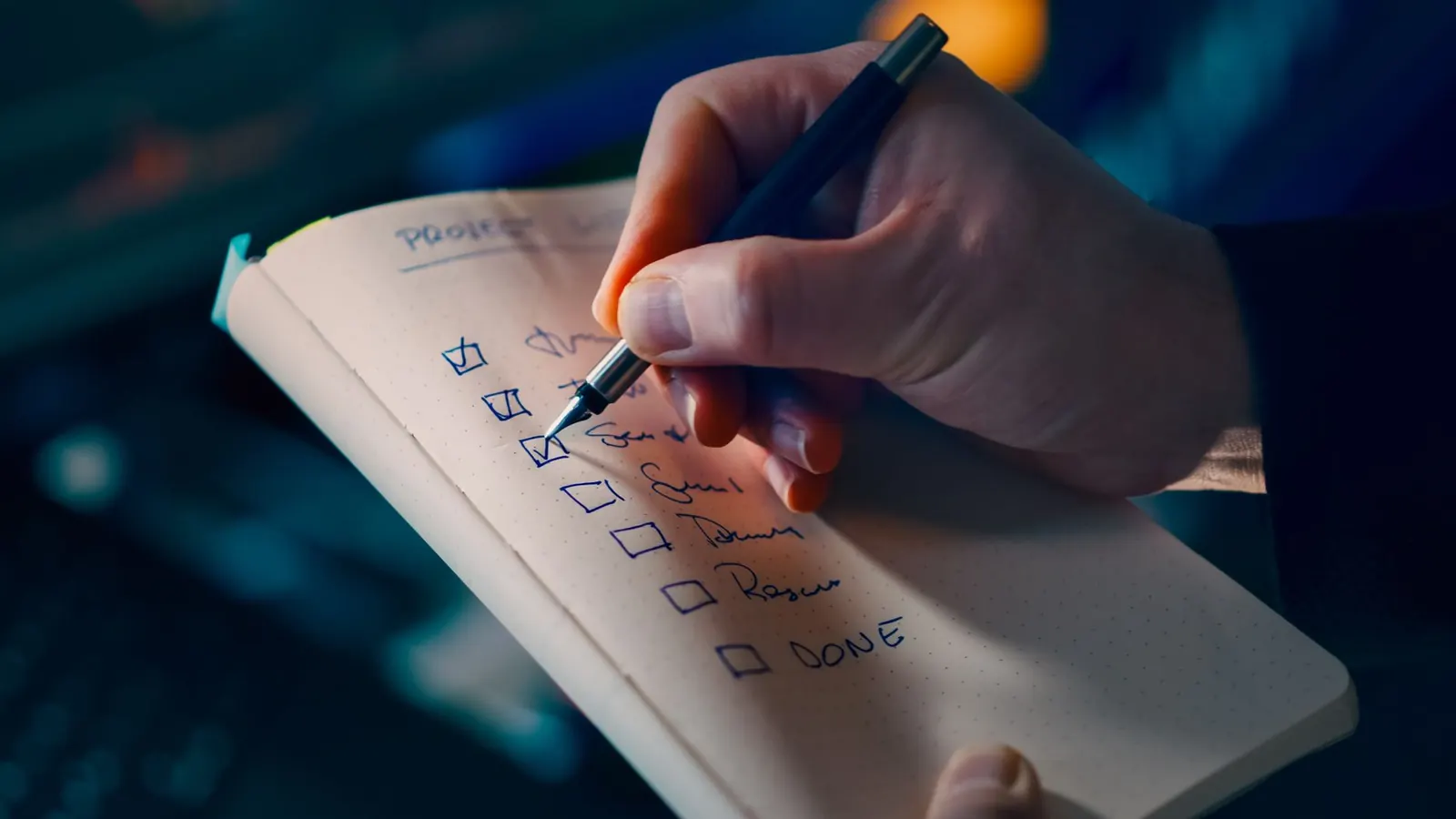 A hand checking off items on a handwritten checklist, representing controls being sized and implemented to match a business's actual fraud risk