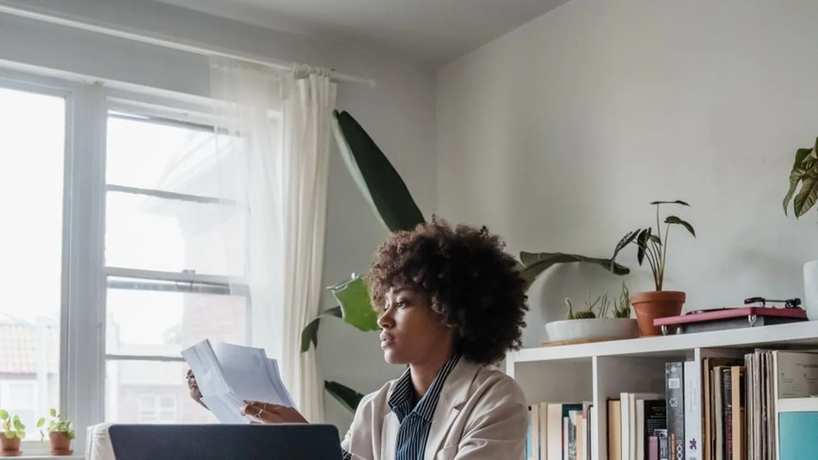 A businesswoman reviewing scattered paperwork at a cluttered desk, representing the limits of remote due diligence