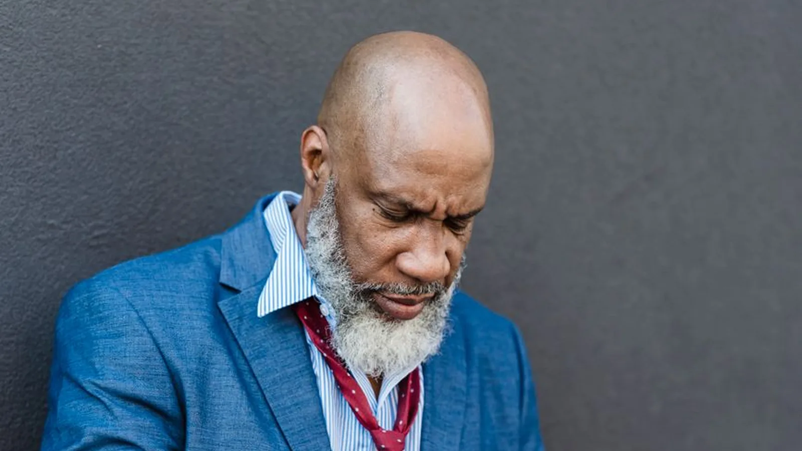 An older businessman frowning with concern while reading through papers, representing the risks of skipping local verification