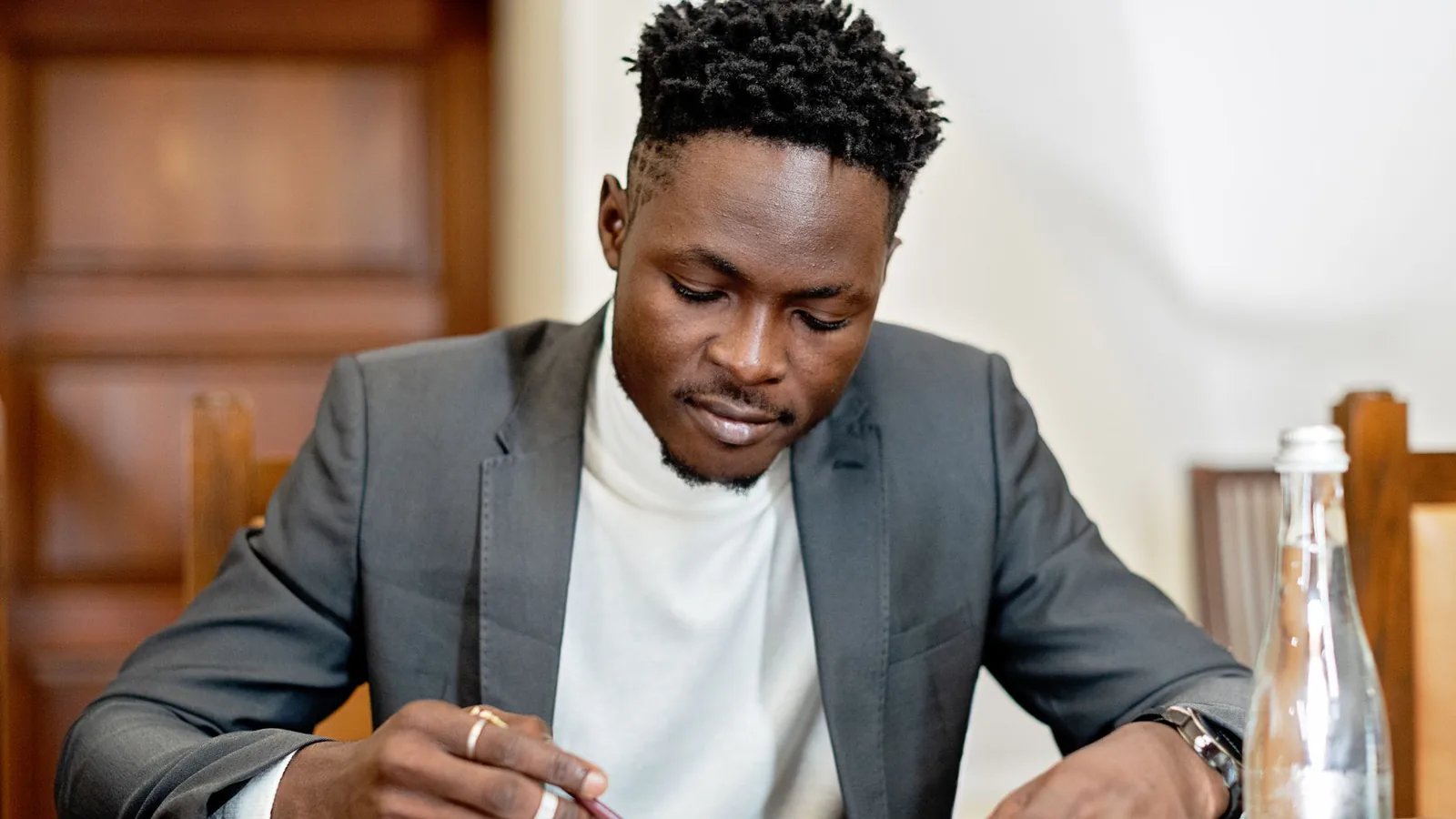 A man in a blazer reviewing a legal document at his desk, representing what to check before hiring a private investigator in Tanzania