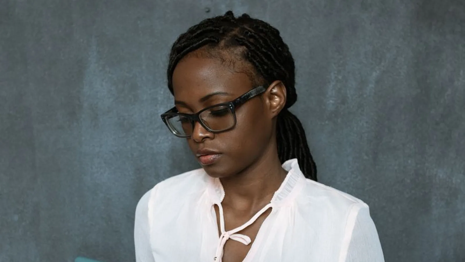 A woman reading her phone screen with a skeptical expression, representing the caution worth applying to unverified private investigator pitches