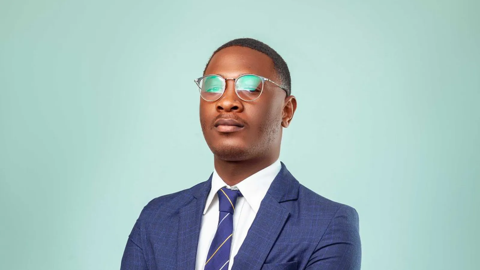 A confident businessman in a suit with his arms crossed, representing the professional behind either title, detective or investigator