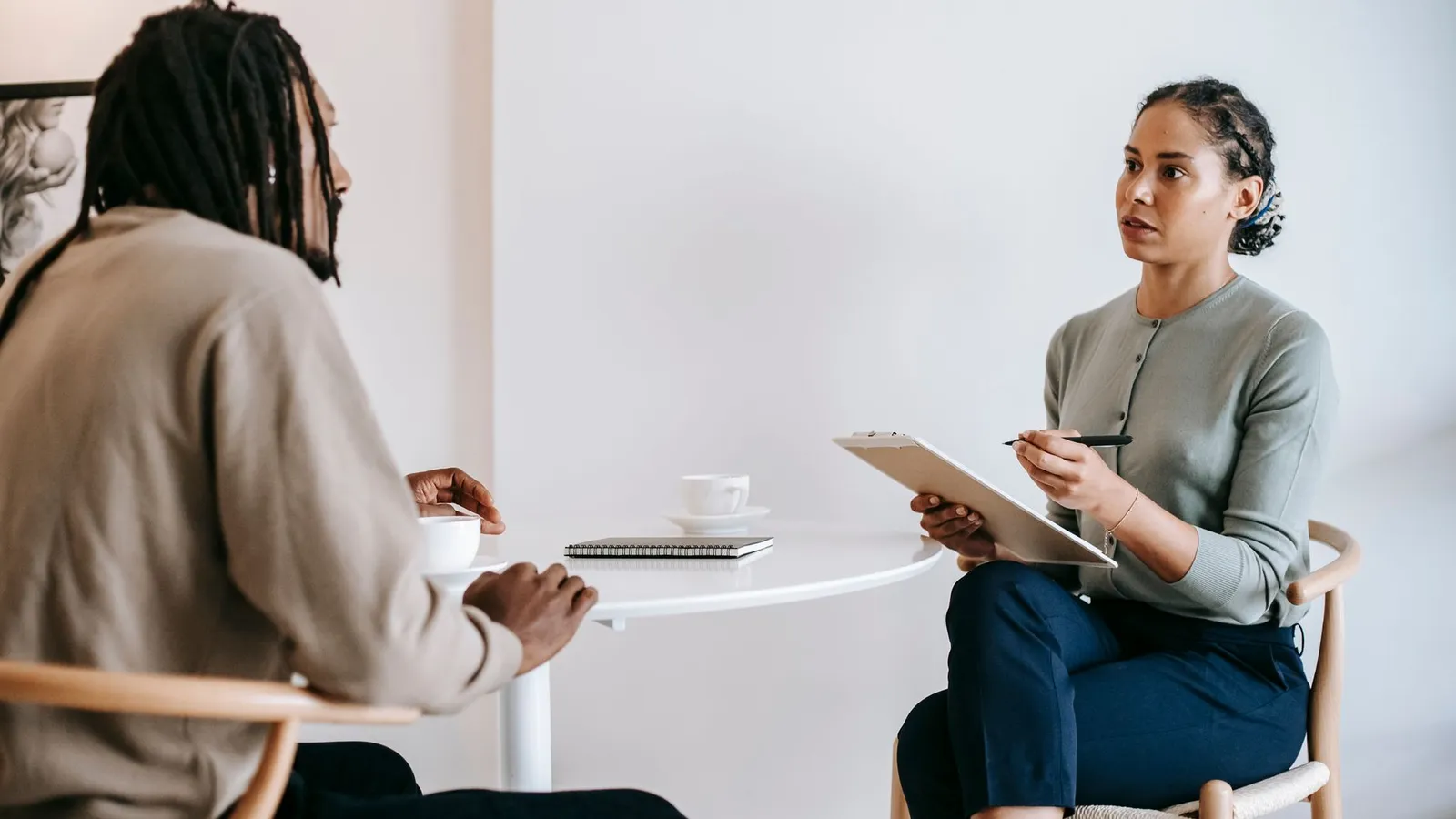 A consultation between a client and an investigator at a table, representing the questions that actually matter more than a firm's chosen title