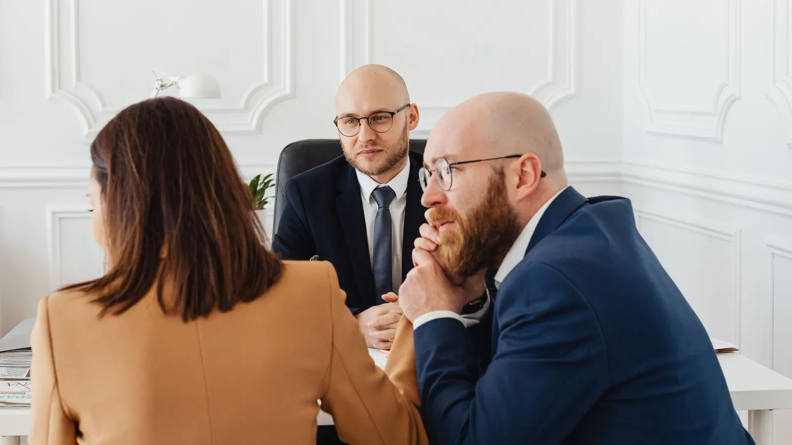 Three colleagues in a client consultation meeting, representing the initial conversation before hiring a private investigator