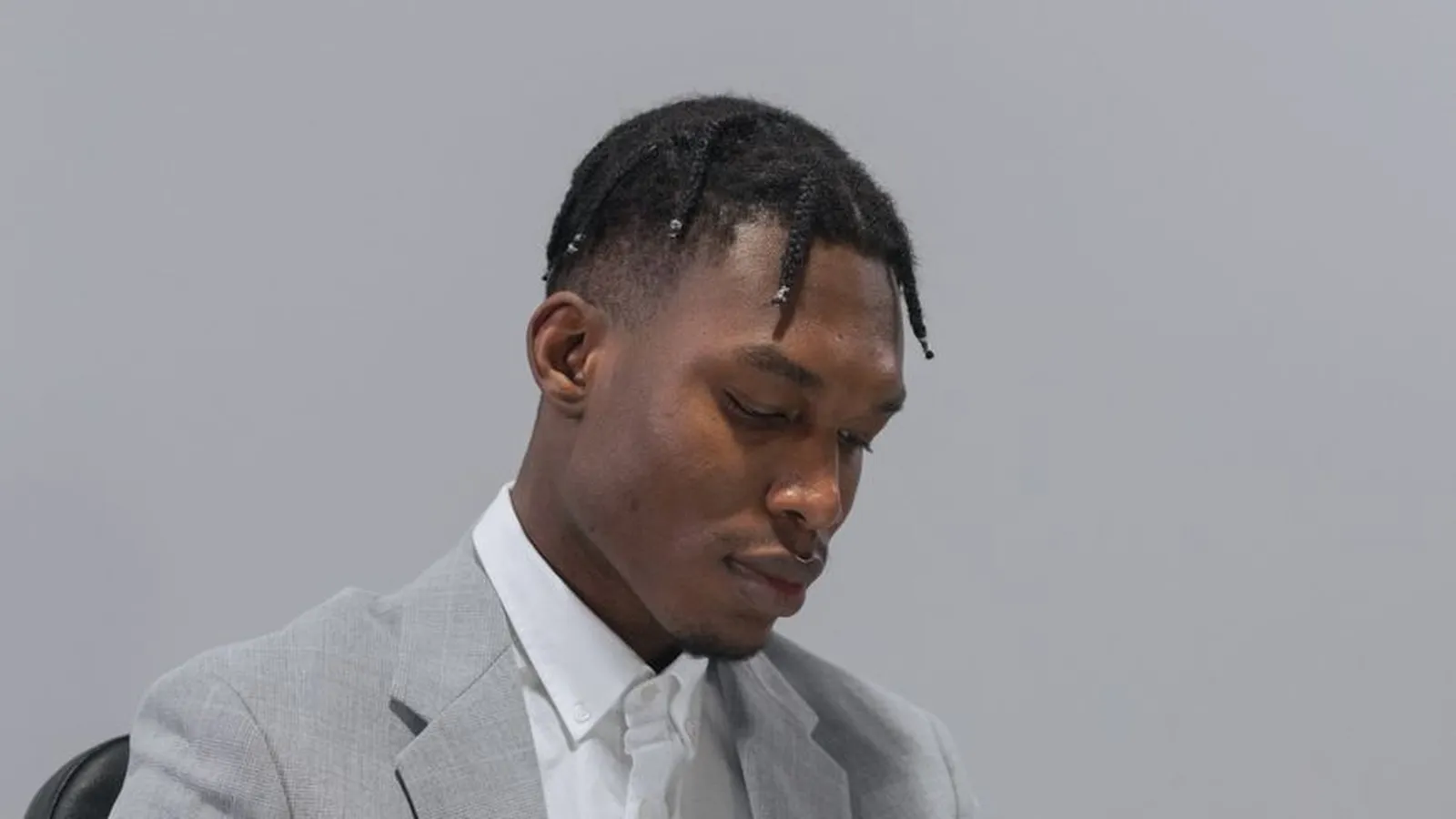 A man in a suit reviewing a document at his desk, representing the legal and registration questions worth confirming before hiring a firm