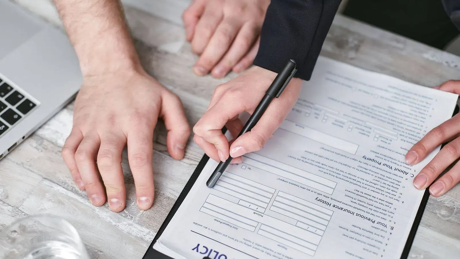 Hands reviewing an insurance policy document on a clipboard
