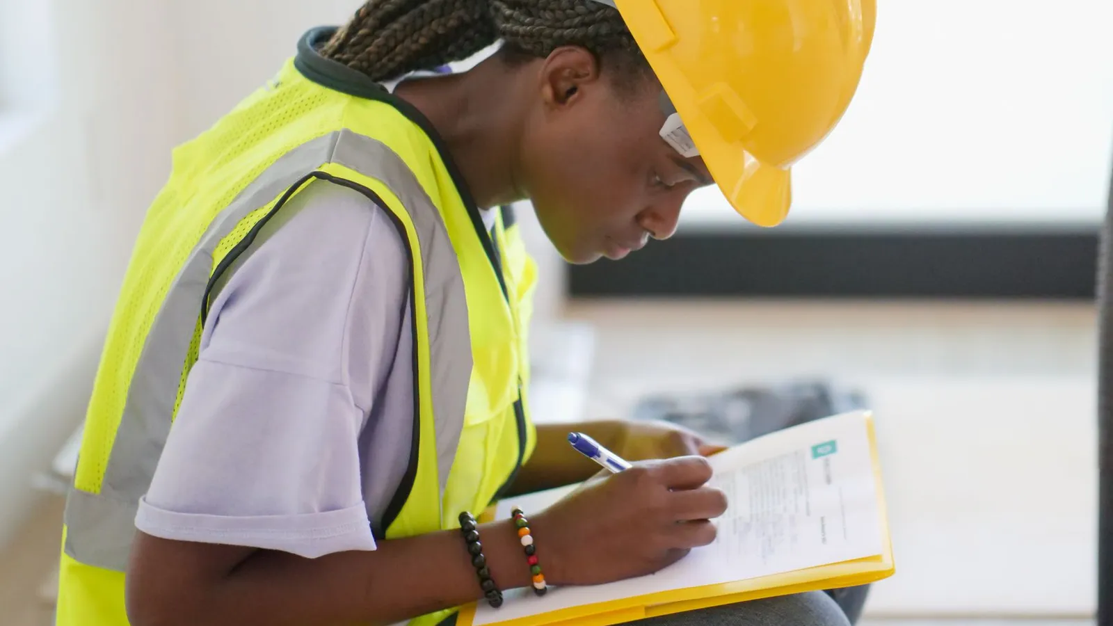 An investigator in high-visibility gear taking notes on a clipboard during a site inspection, representing the documentation behind an independently verified insurance claim