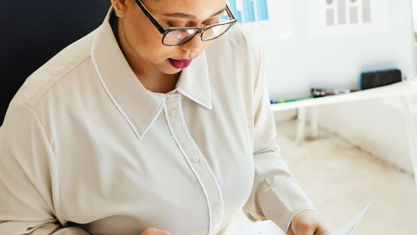 A businesswoman reviewing a financial chart with a pencil, representing the pattern-tracking that catches fraud before it compounds