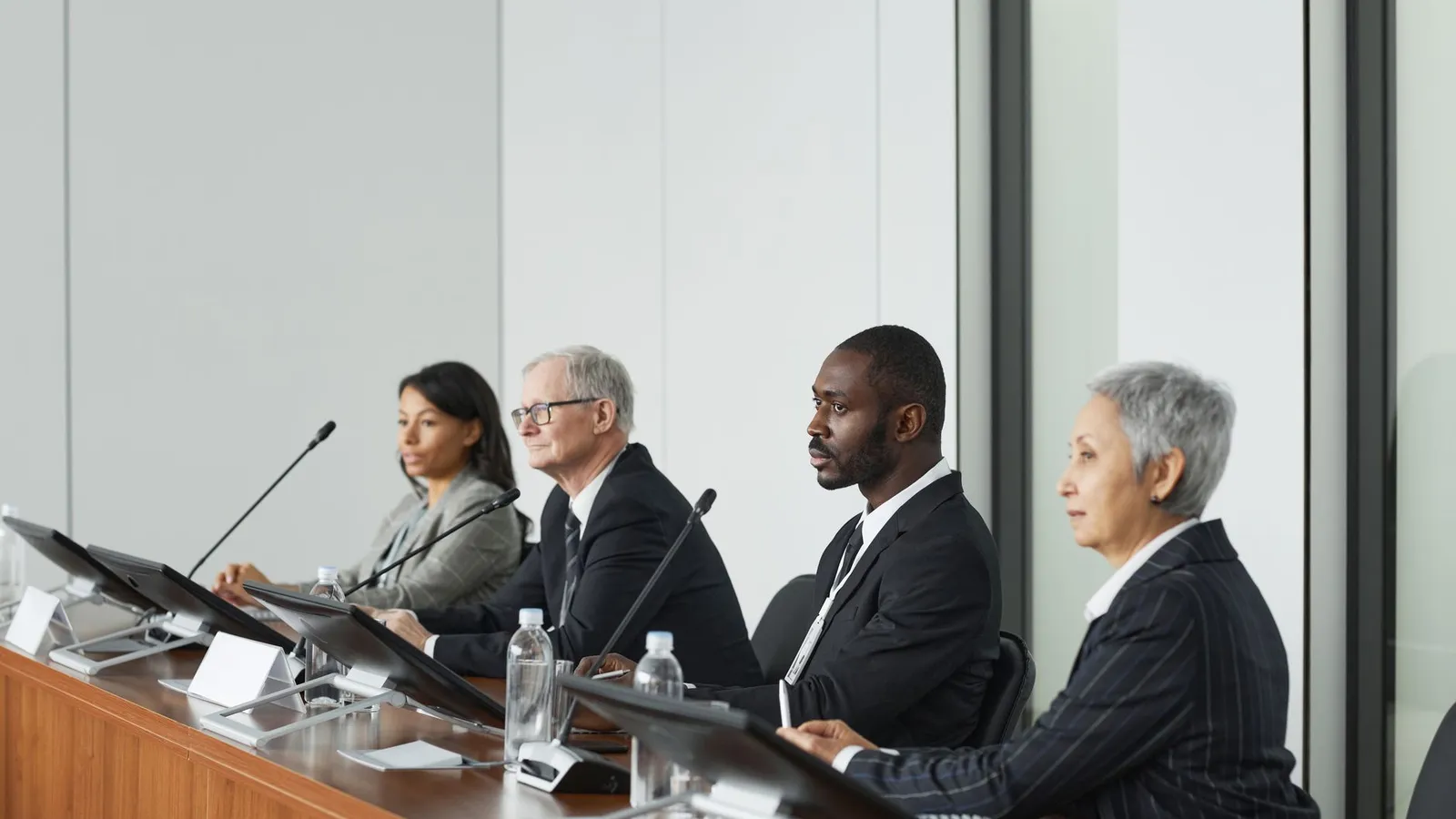 A panel of interviewers evaluating a senior candidate in an office, representing how polished a senior hire can appear without proper background verification