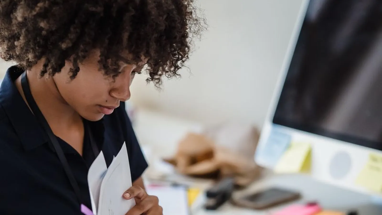 A woman reviewing paperwork at her desk with a concerned expression, representing the moment a financial discrepancy stops looking like a coincidence