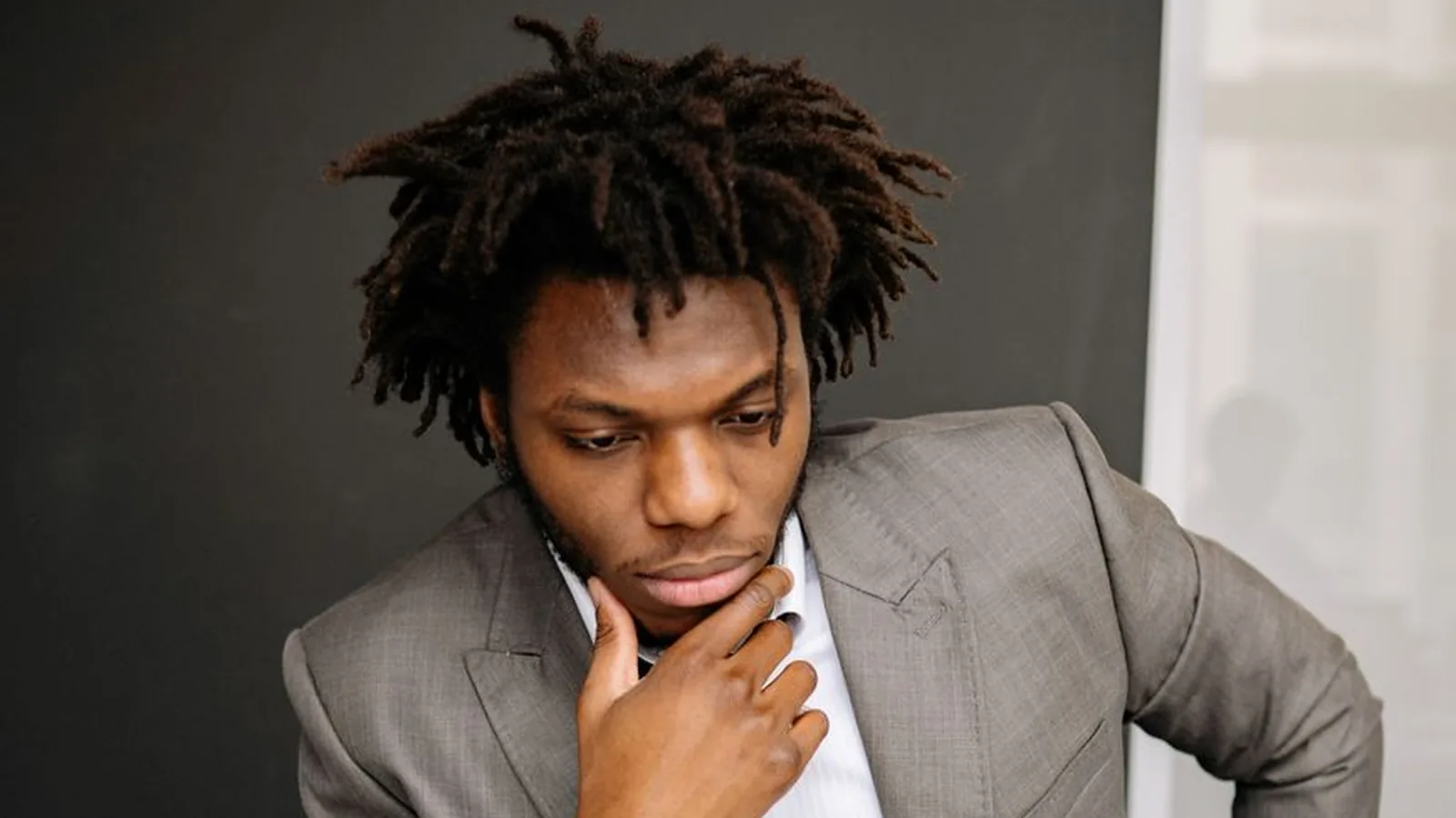 A man in a suit pausing in thought, representing the moment a business owner decides to call a private investigator