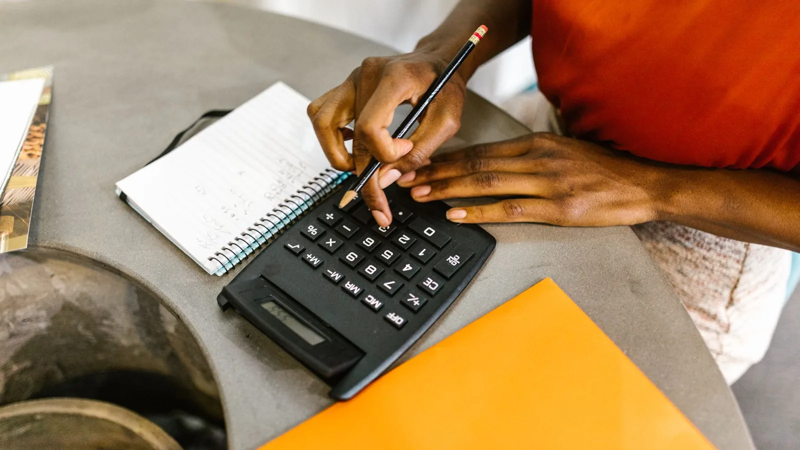 A person's hands using a calculator and notebook, representing the moment a routine reconciliation turns up an unexplained discrepancy