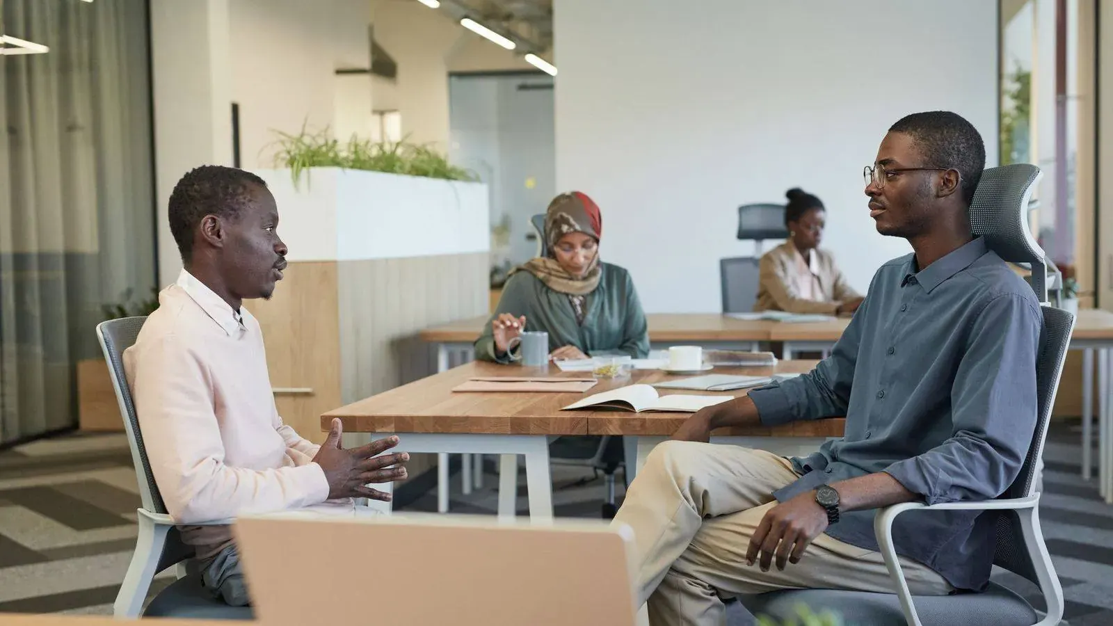 Colleagues in discussion at a modern African office, representing a business decision that may call for an investigator