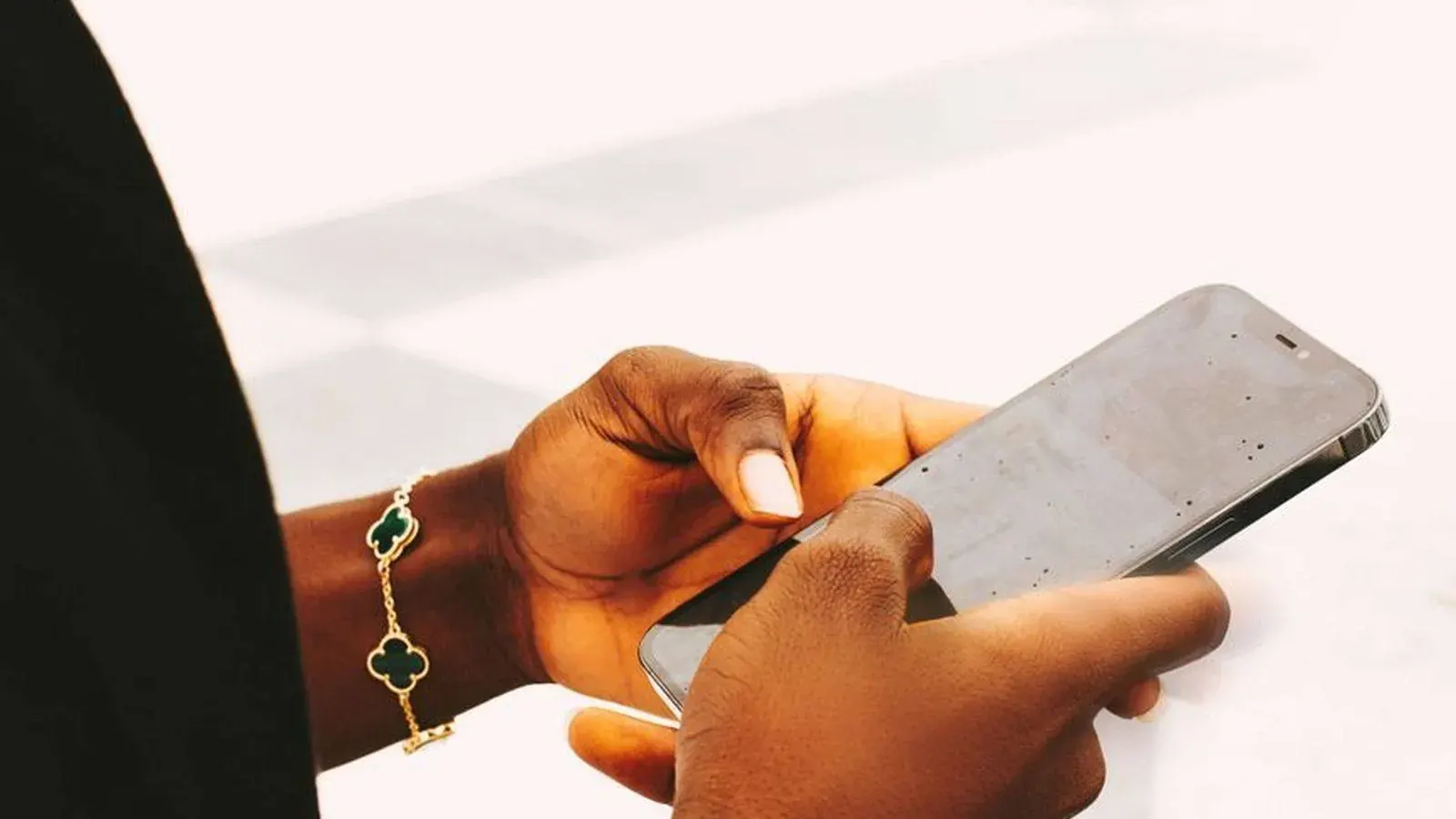 Close-up of hands using a smartphone, representing how fast a mobile money transfer can move in Tanzania