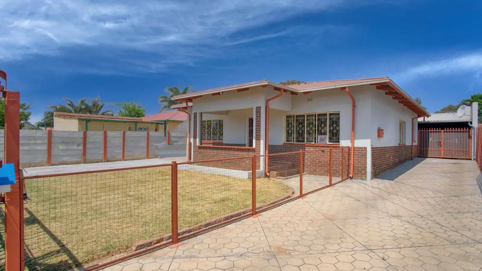 Residential house with a gated fence in Tanzania, representing a property or title verification check