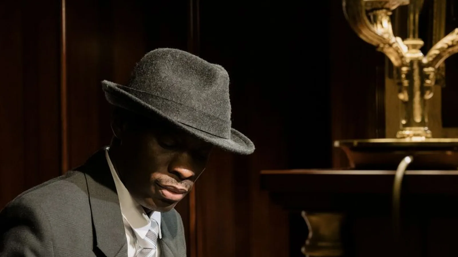 A man in a fedora hat and suit, representing the popular, movie-style image of a private investigator