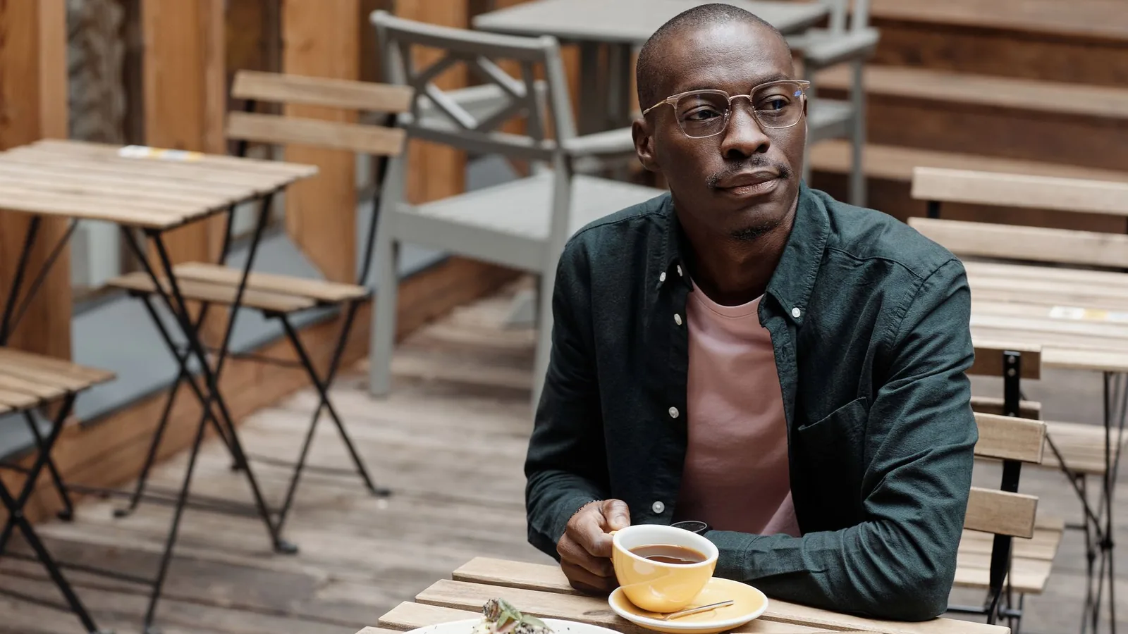 A man sitting quietly and observantly at an outdoor table, representing the patience and discretion the work actually requires